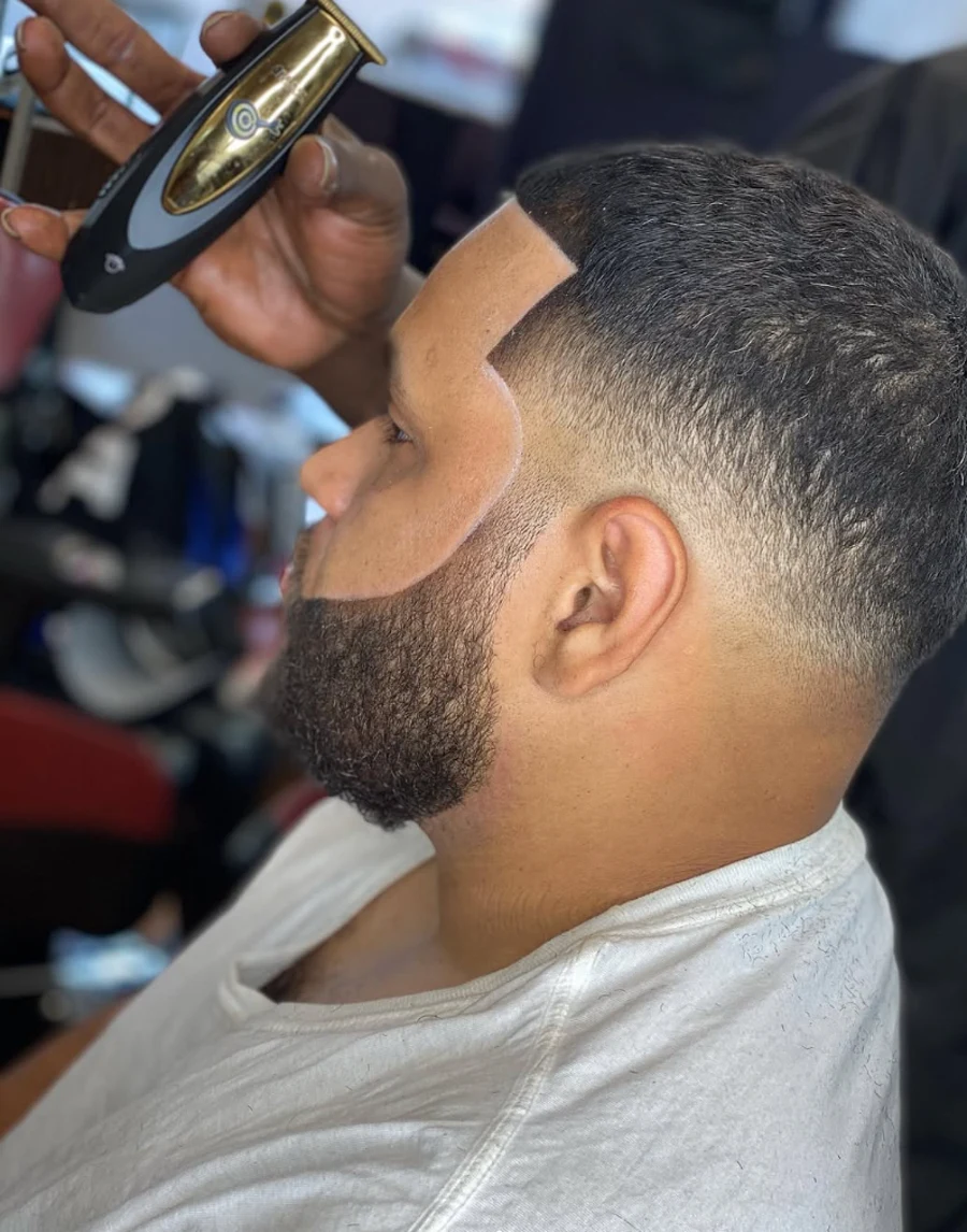 Close-up of Marqi shaping the finished hairline and beard